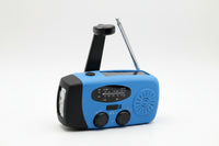 Blue and black portable radio with flashlight on a gray background